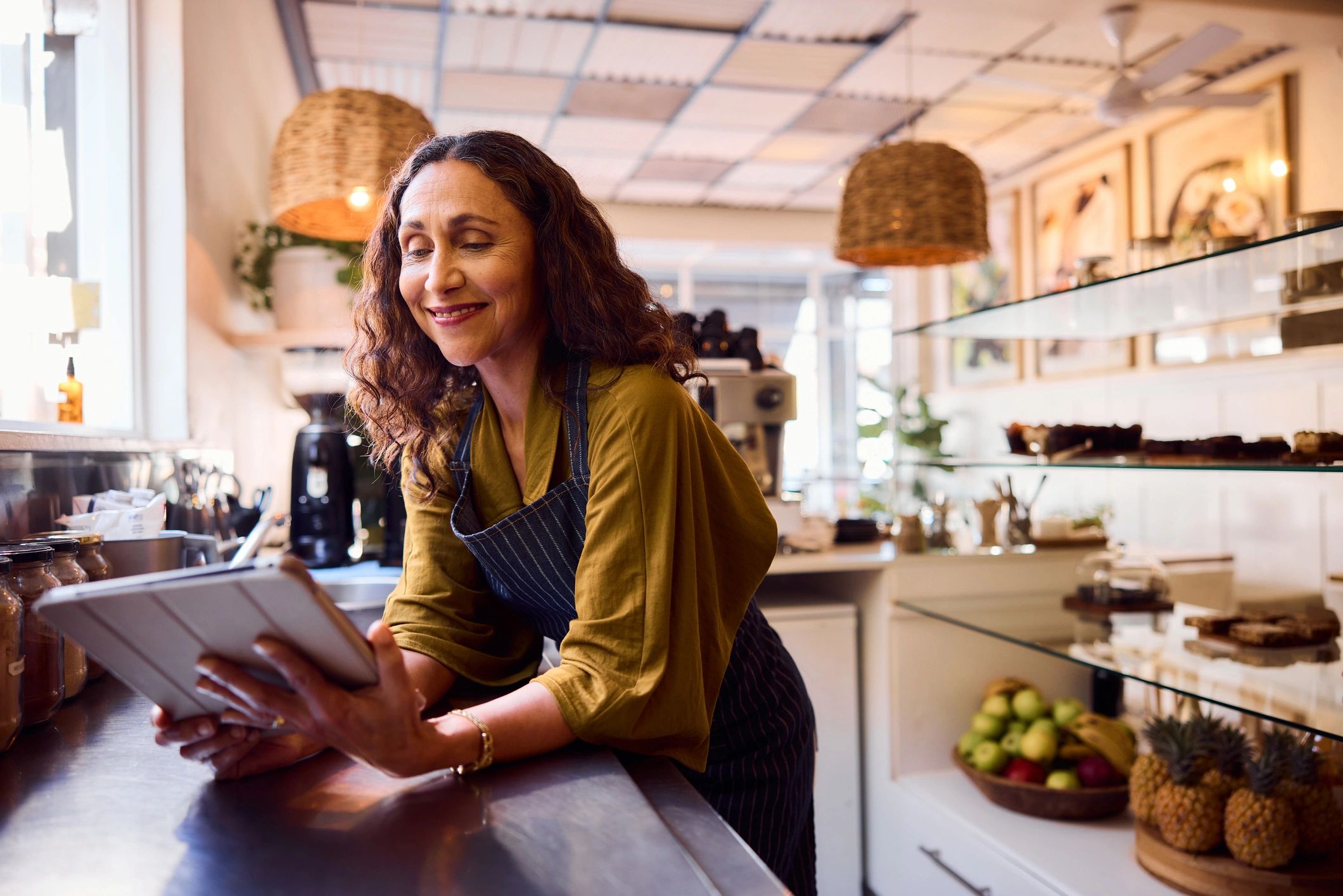 Small business owner smiling while working with a tablet